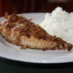 Crispy Onion Chicken on a white plate with mashed potatoes next to it
