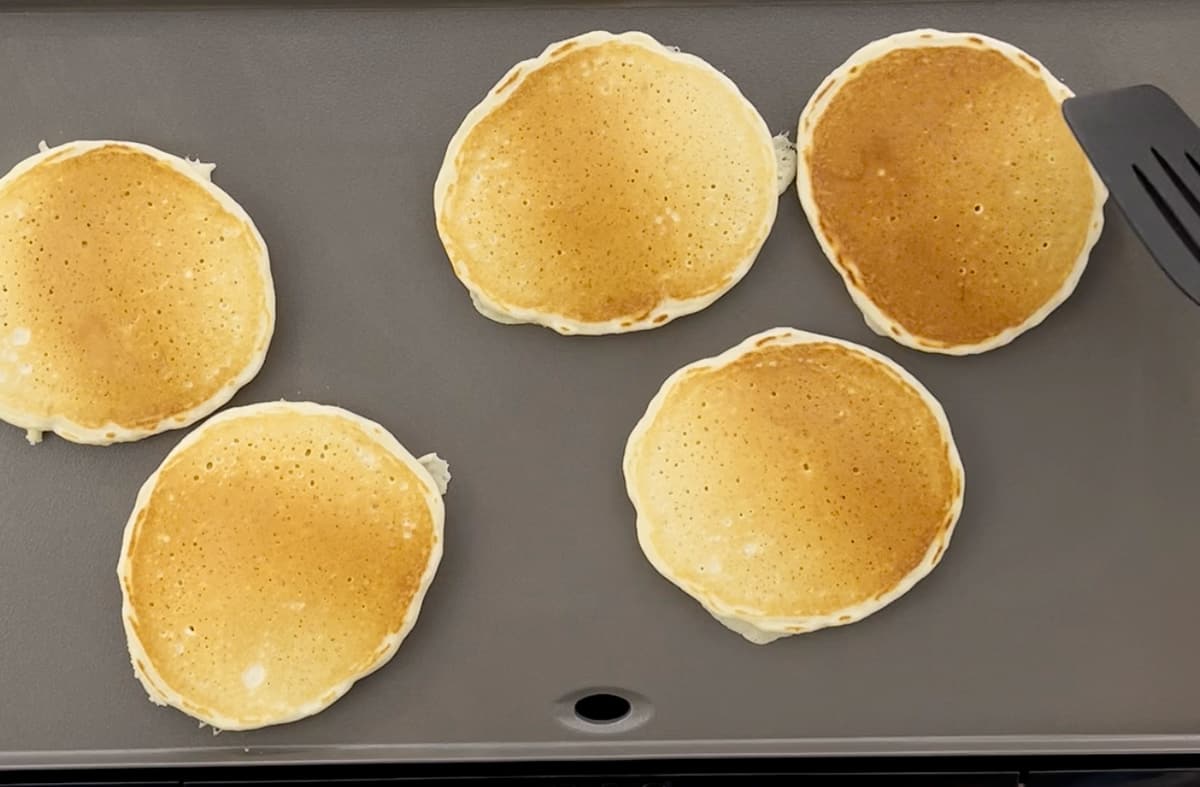 Flipping pancakes on an electric griddle.