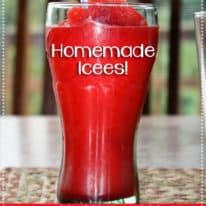 A red homemade icee in a glass with a straw