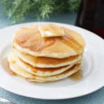 A stack of homemade pancakes with butter and syrup.