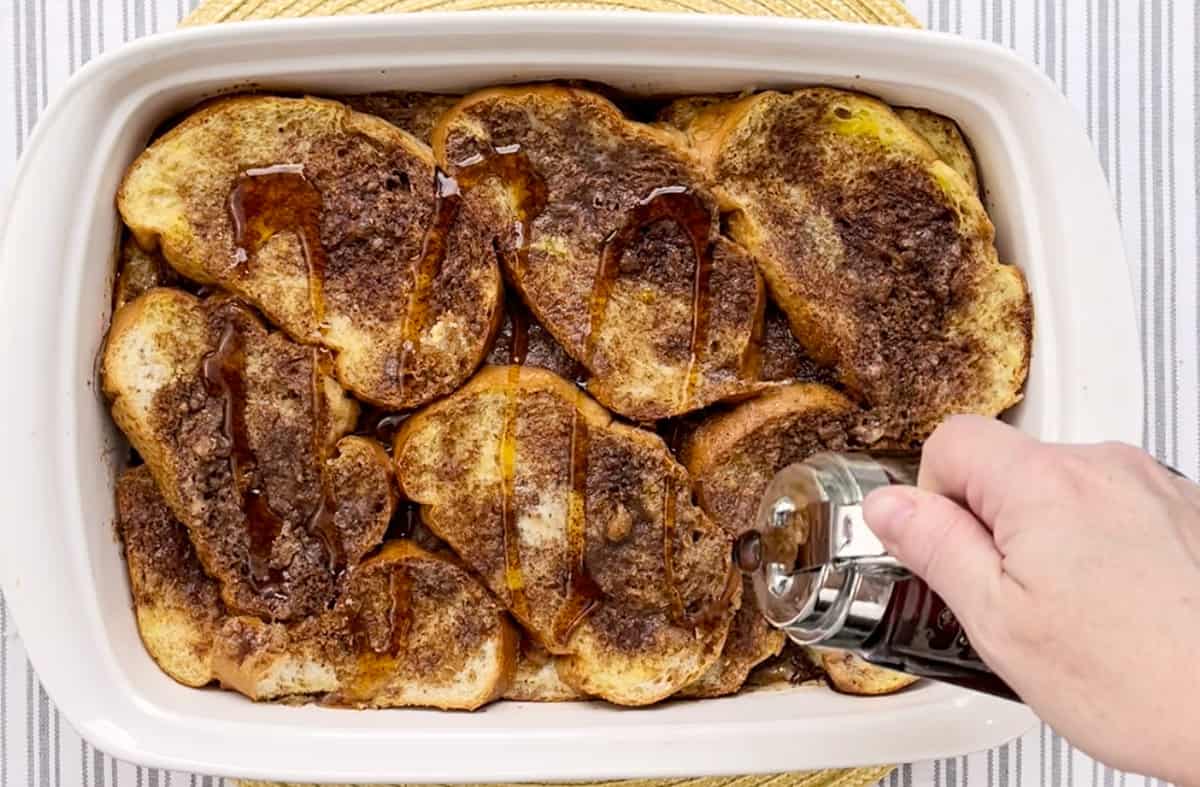 Drizzling maple syrup over French toast casserole.