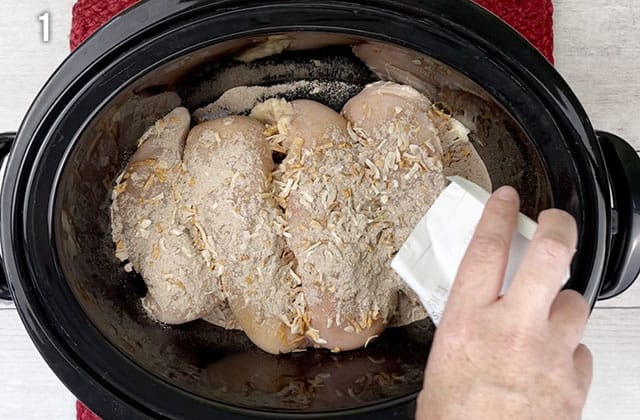 Sprinkling onion soup mix on top of chicken breasts in the Crockpot