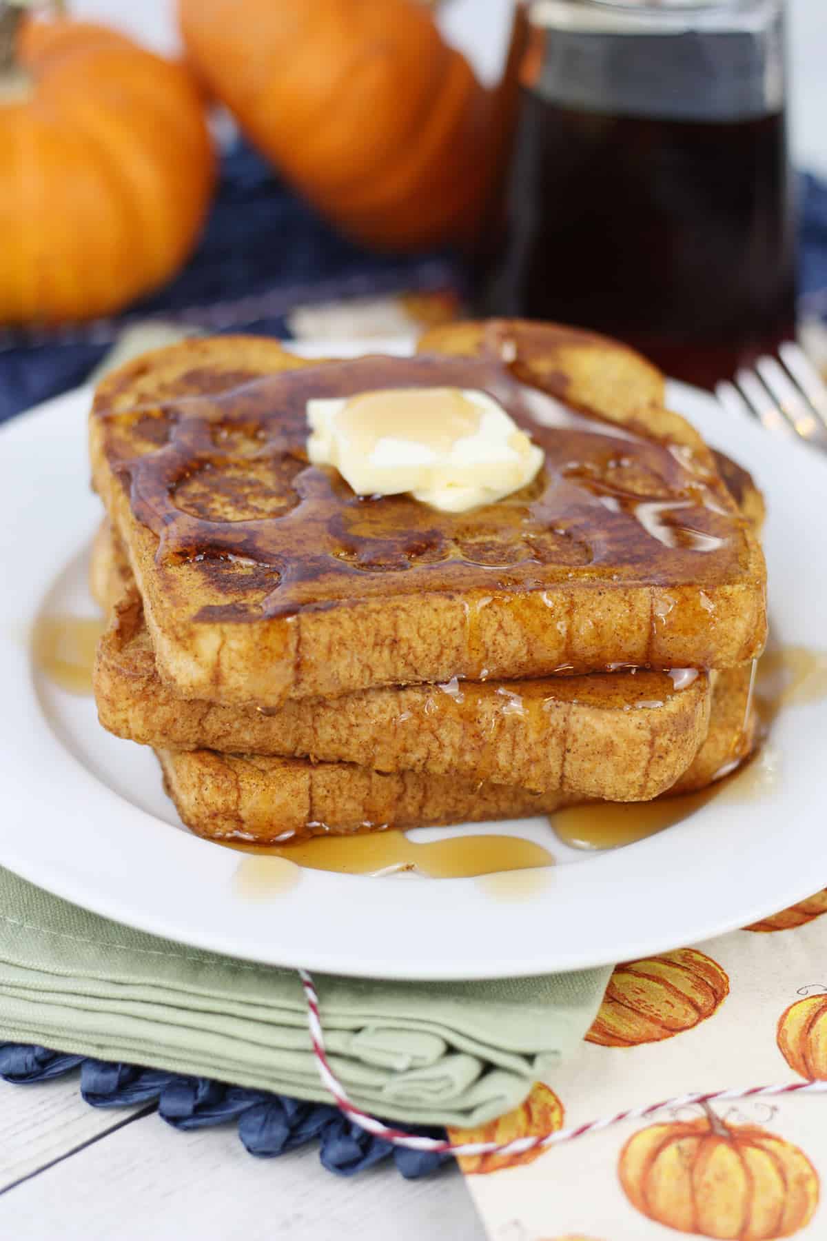 Slices of pumpkin French toast on a white plate.