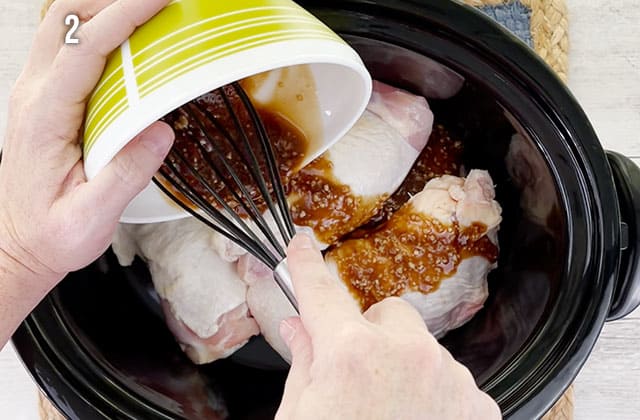 Pouring soy sauce over chicken thighs in a slow cooker