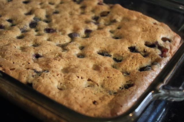Blueberry crumb bars being baked in a glass dish.