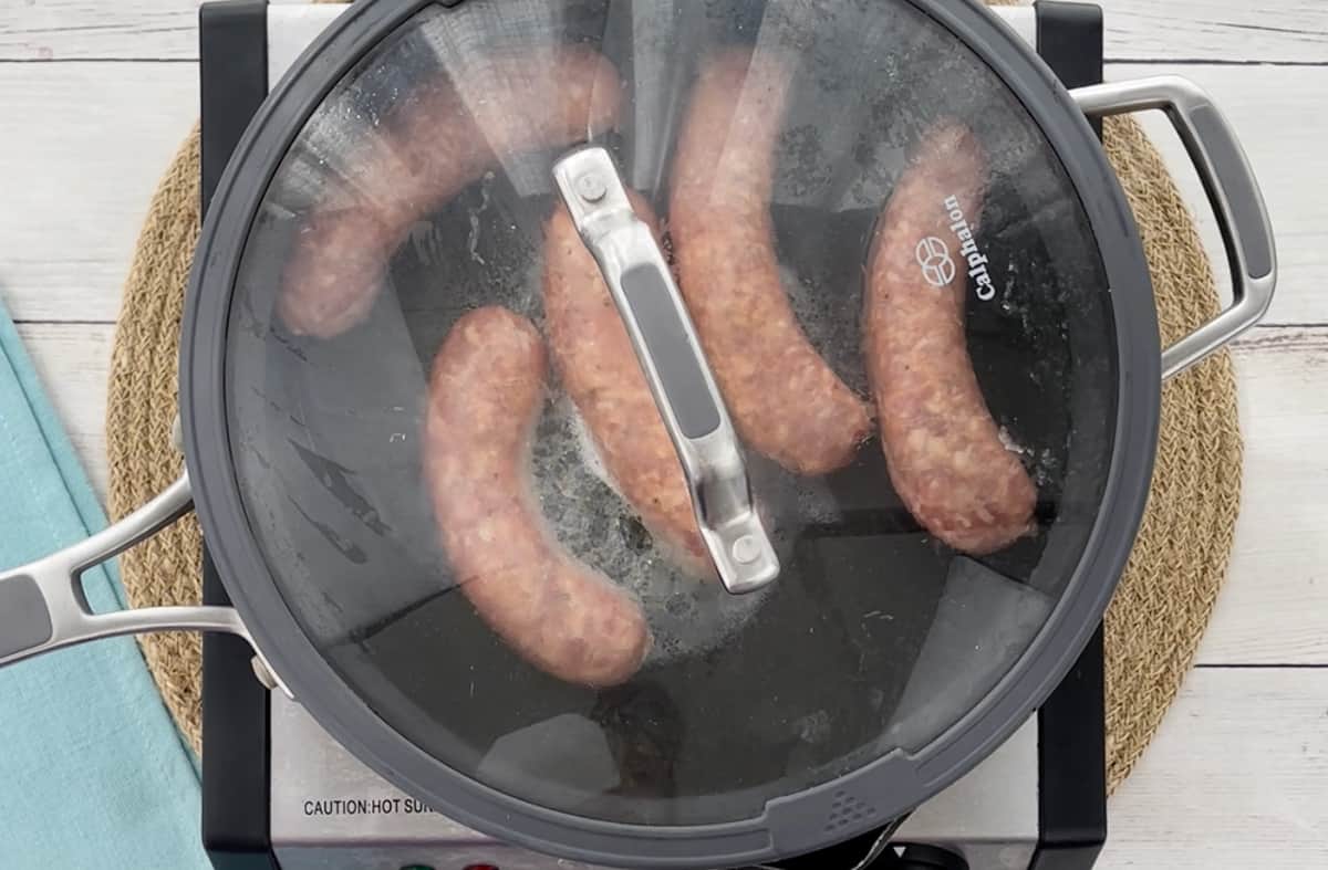 Cooking sausage links in a skillet.