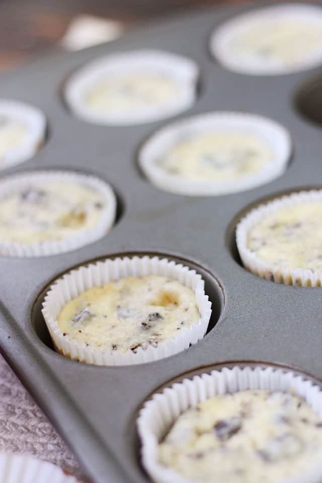 Mini Oreo cheesecakes baked in a silver muffin tin