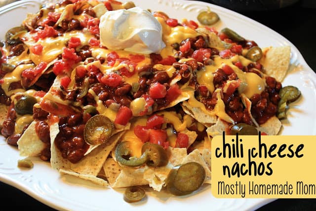 A platter of chili cheese nachos being served.