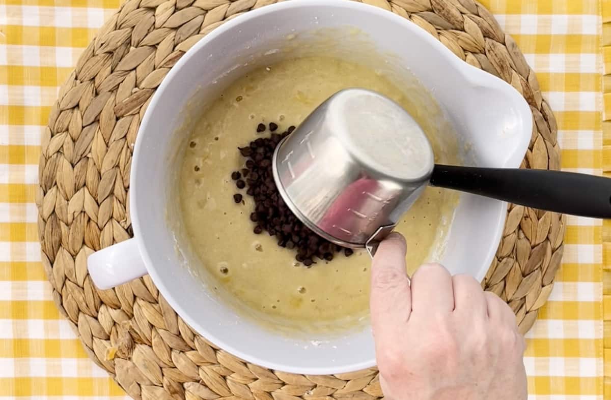 Stirring chocolate chips into banana bread batter.