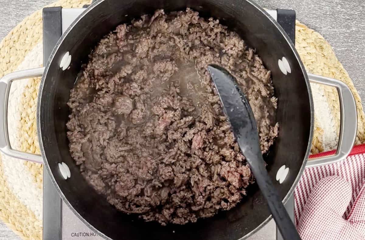 Cooking ground beef in a pot on the stove.