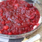 Cranberry dip with cream cheese in a pie plate next to crackers