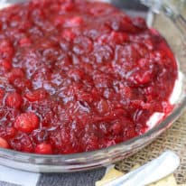 Cranberry dip with cream cheese in a pie plate next to crackers