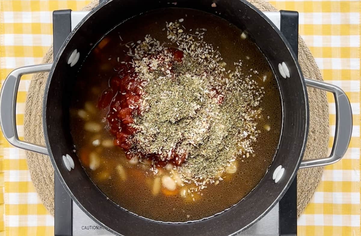 Alphabet soup ingredients in a large pot on a skillet.