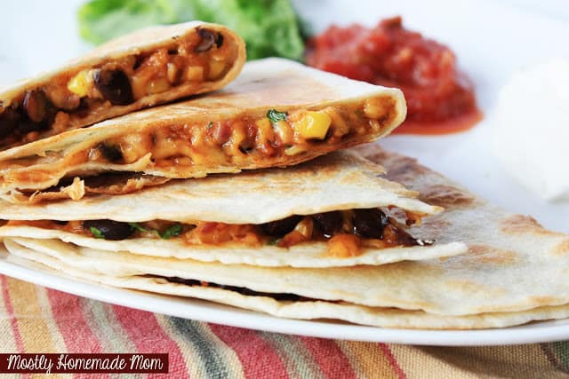 Corn and black bean quesadillas being served on a white plate.