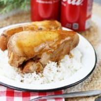 Coca cola chicken over white rice in front of cola cans.