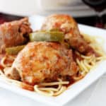 Slow cooker chicken cacciatore on a white plate in front of a Crockpot.