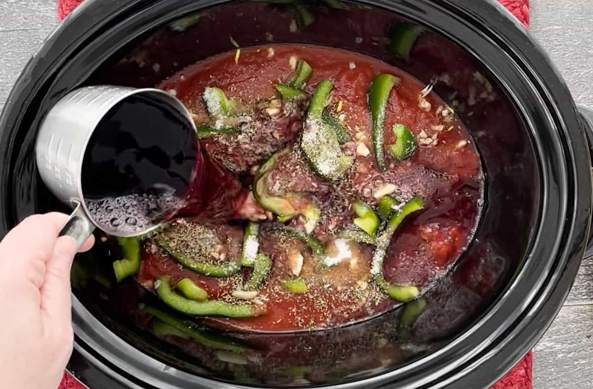 Pouring red wine into a Crockpot.