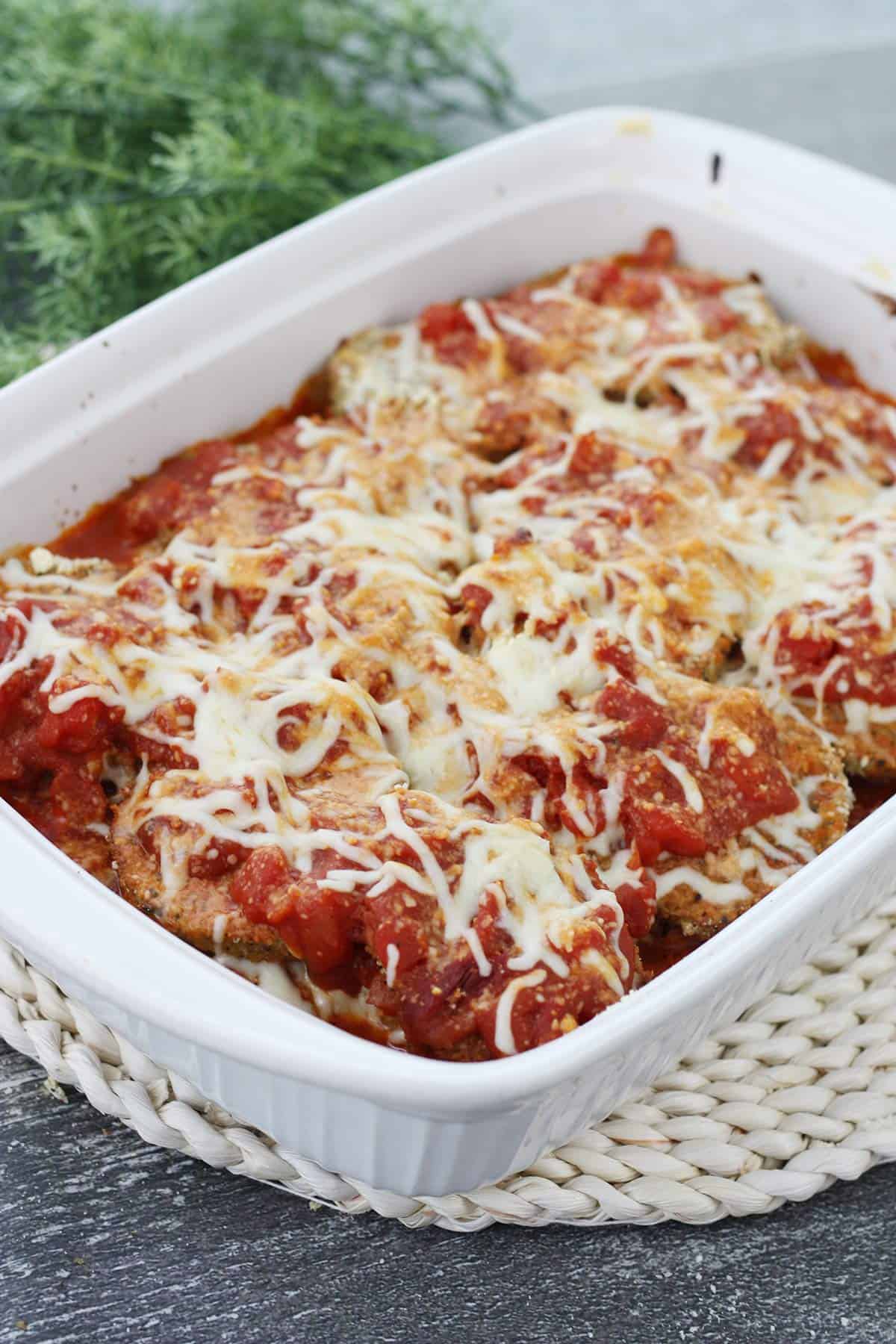 Baked Eggplant Parmesan in a white baking dish.