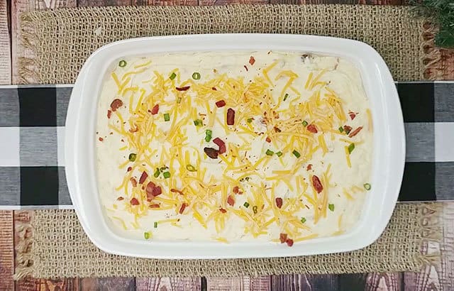 Loaded mashed potato casserole in a baking dish ready to be put into the oven
