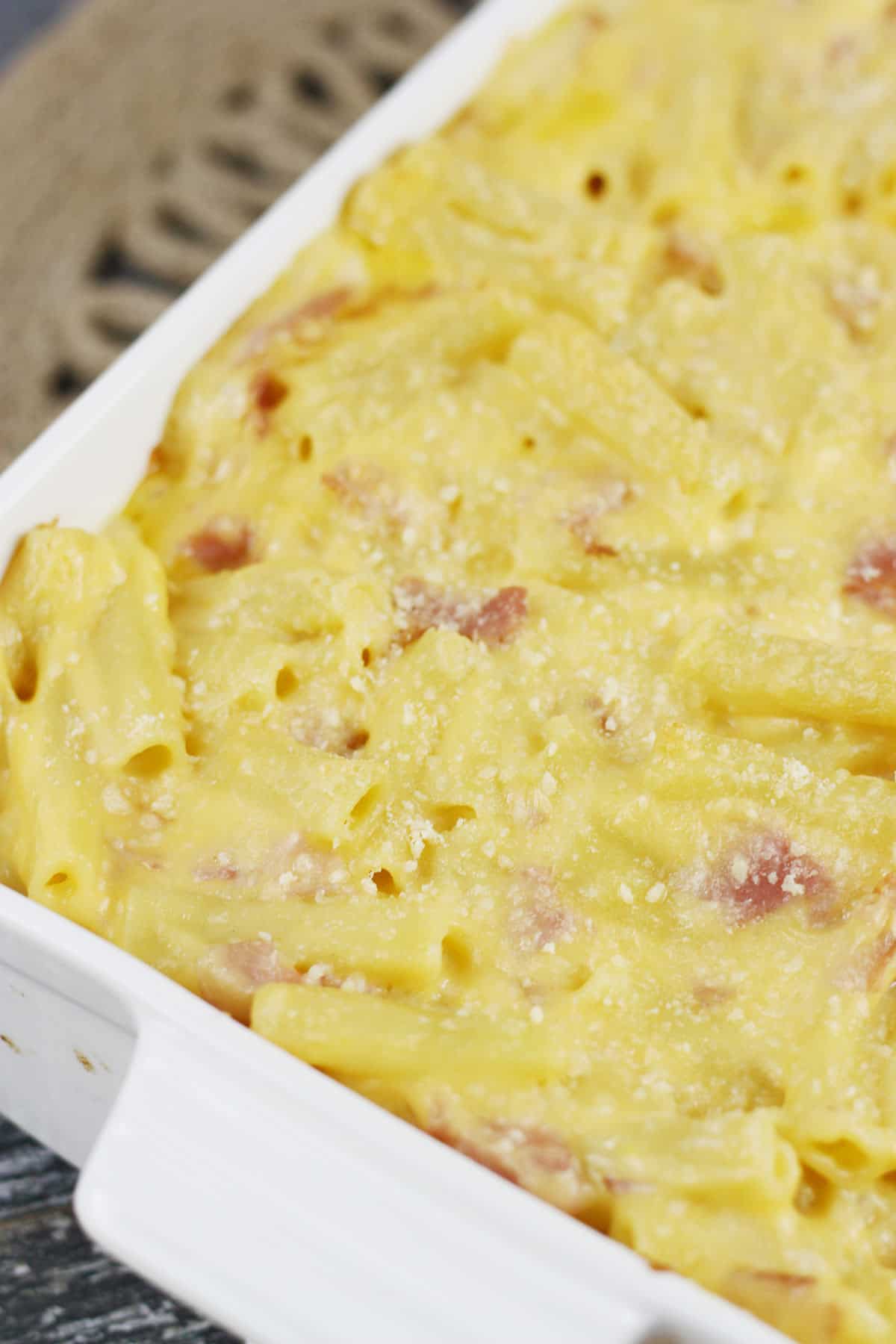 Ham and cheese casserole being served in a white dish.
