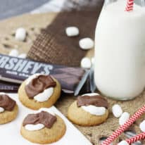 S'mores cookies on a napkin with a glass of milk.