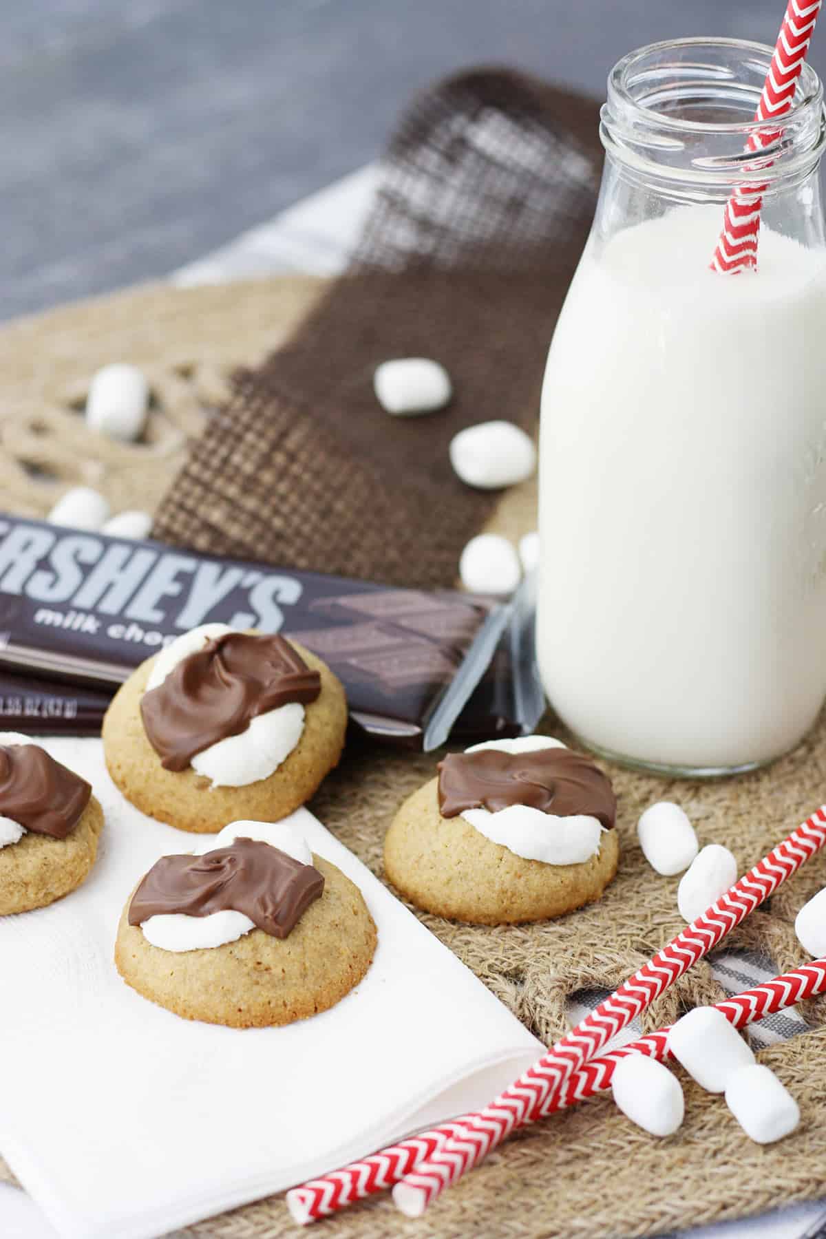 S'mores cookies on a napkin with a glass of milk.
