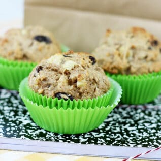 Whole wheat banana muffins in front of a lunch bag.