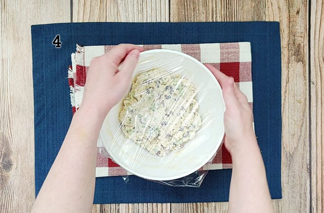 Covering chicken salad with plastic wrap