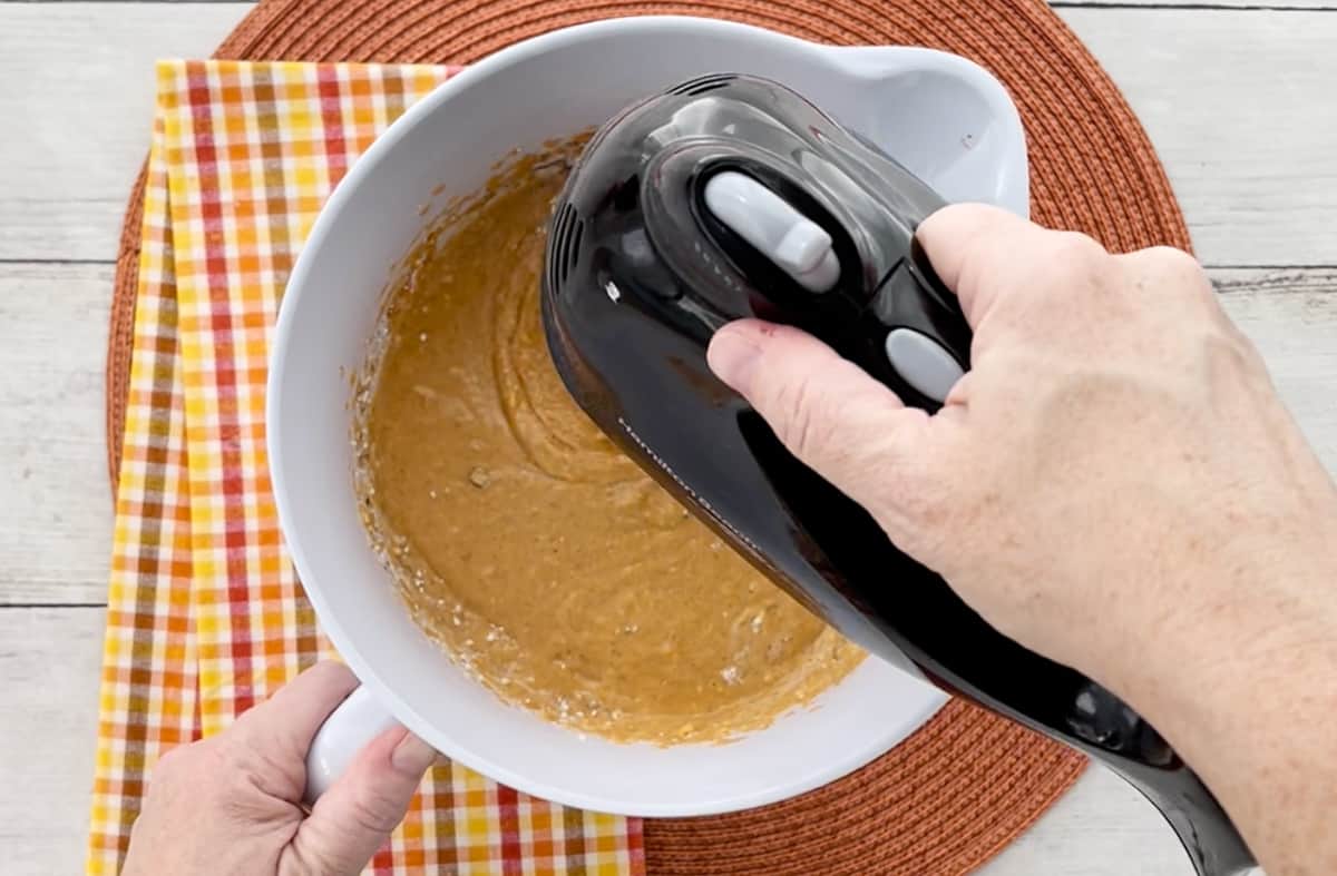Blending the pudding mixture with a hand mixer.