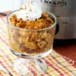 Pumpkin pudding in a glass dish in front of a Crockpot.