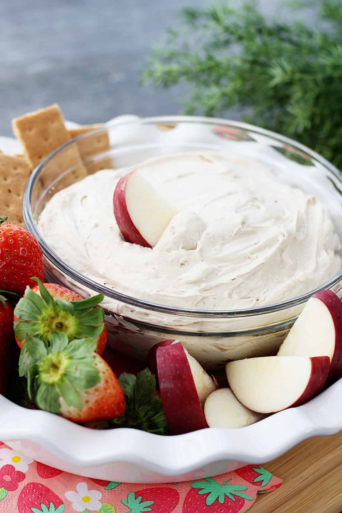 A cream cheese fruit dip surrounded by fruit.