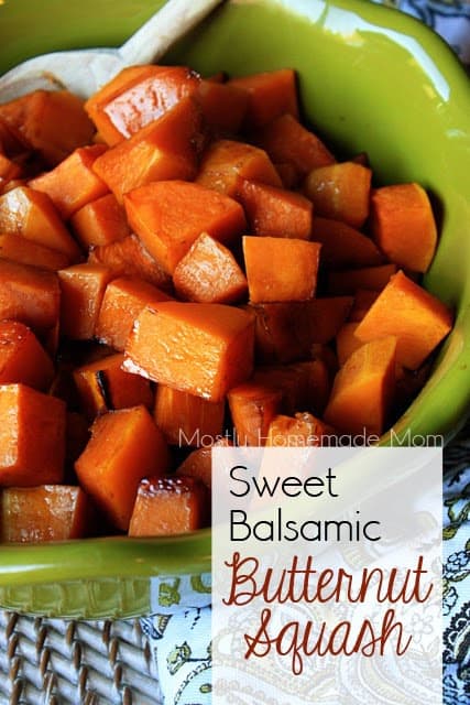 A green bowl with balsamic butternut squash pieces and a wooden spoon.
