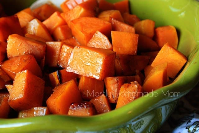 Pieces of balsamic butternut squash in a green bowl.