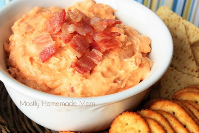 Bacon cheddar dip in a white bowl with bacon pieces on top