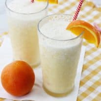 Two glasses of homemade orange julius with straws.