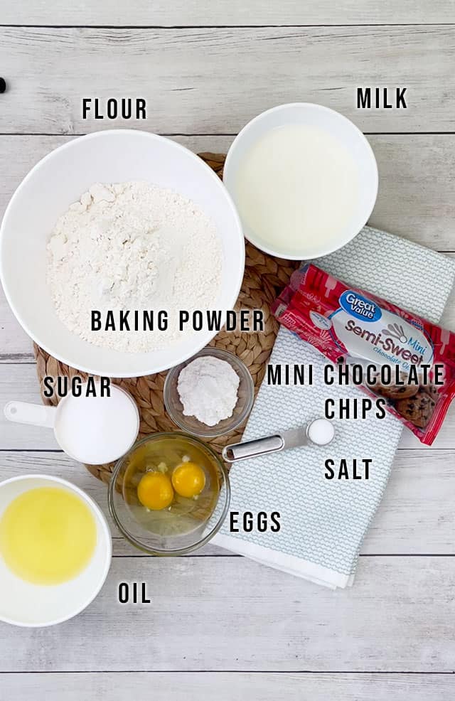 Ingredients for chocolate chip muffins on a white shiplap background