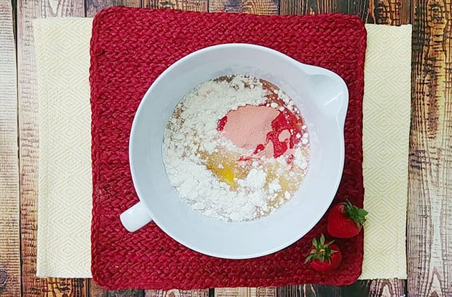 Strawberry jello cake mix batter in a white mixing bowl