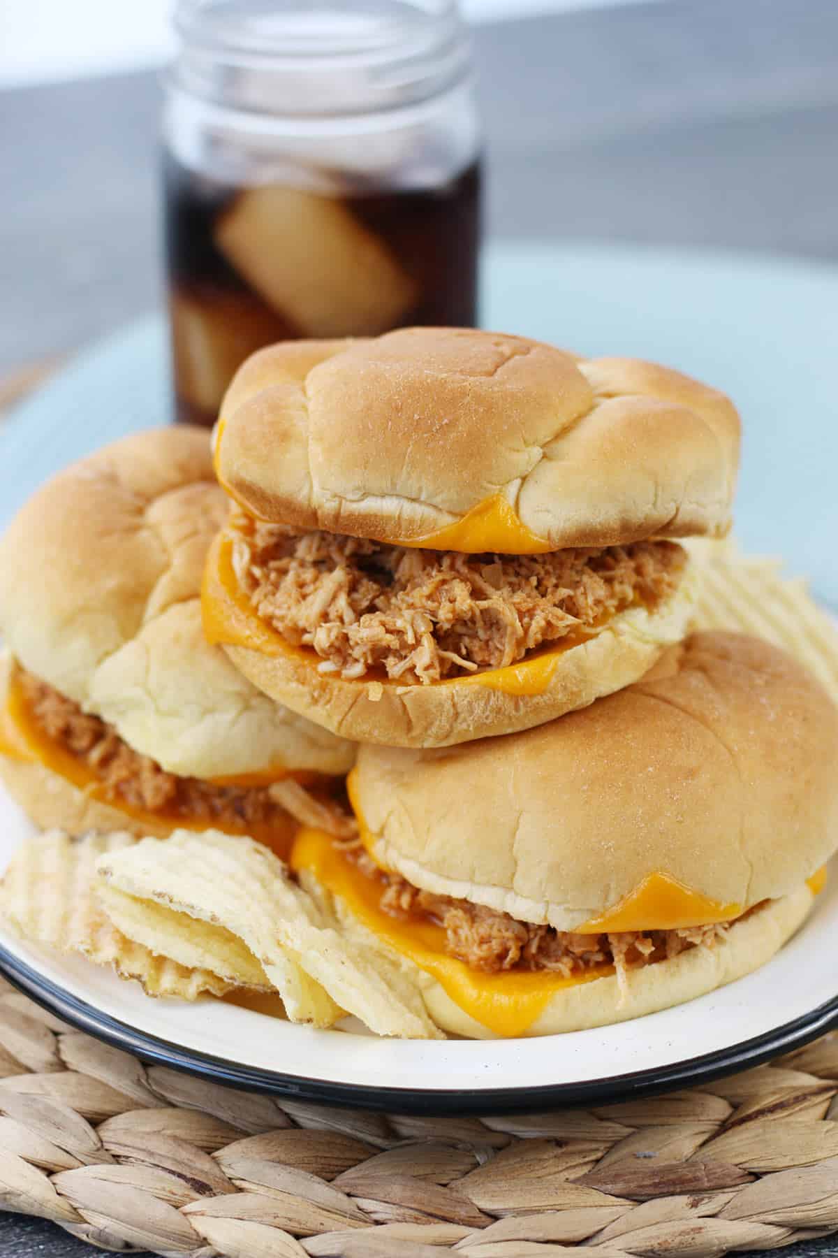 A stack of bbq chicken sandwiches on a plate.