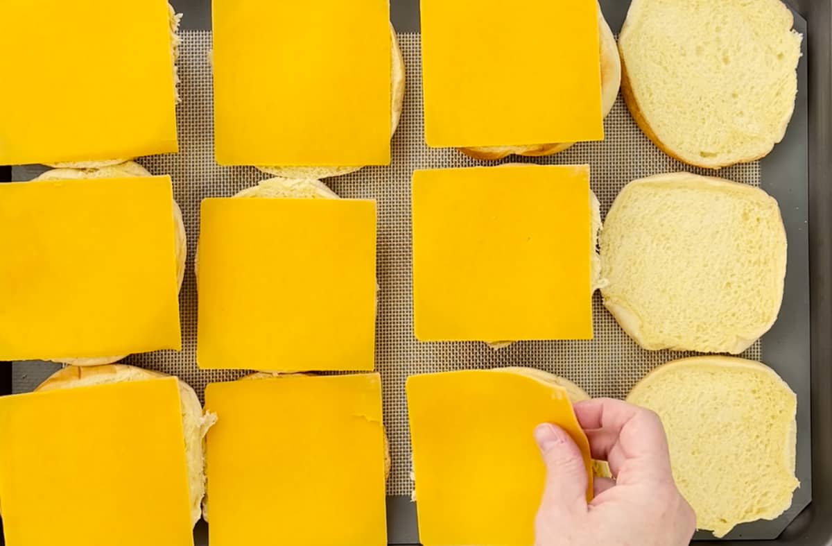 Place slices of cheese on hamburger rolls.
