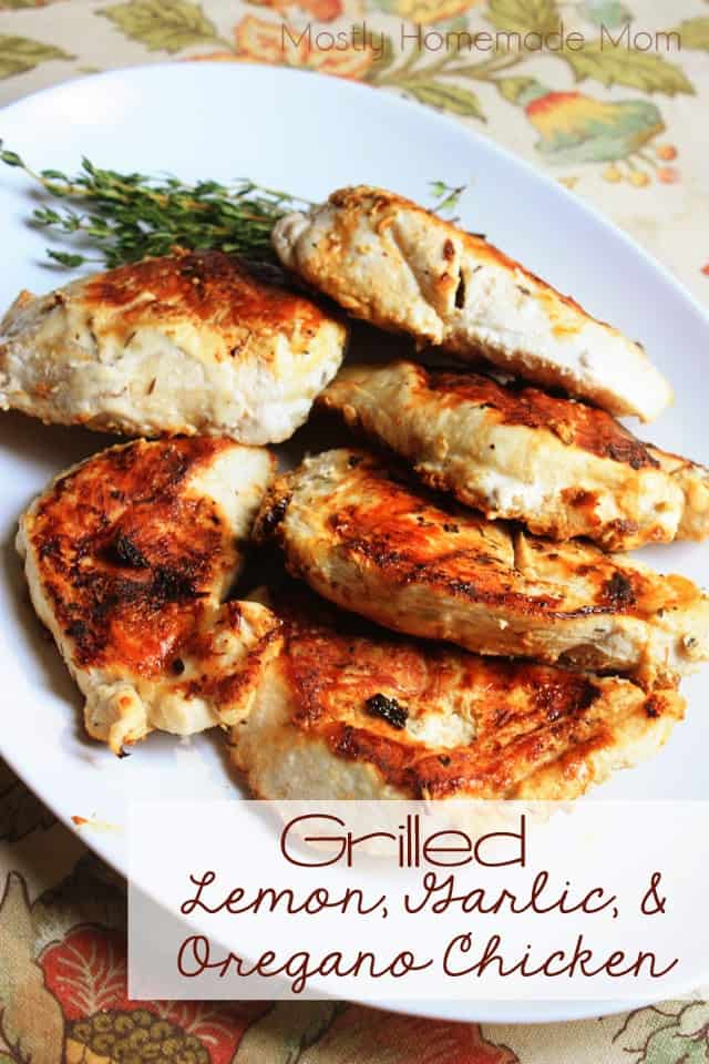 Grilled lemon chicken on a white serving platter with sprigs of thyme