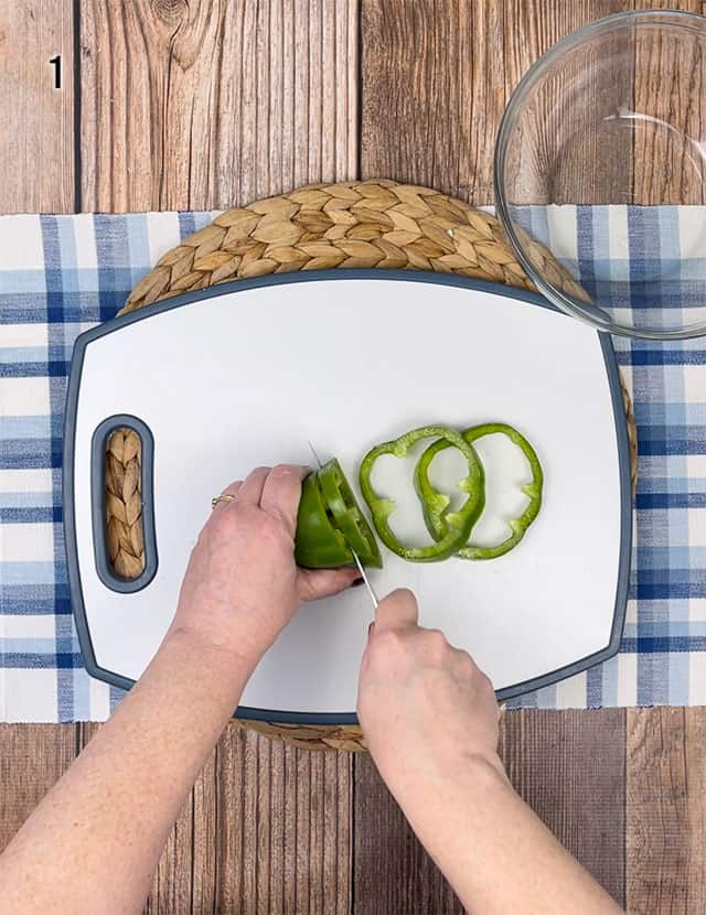 Slicing a green pepper on a white cutting board