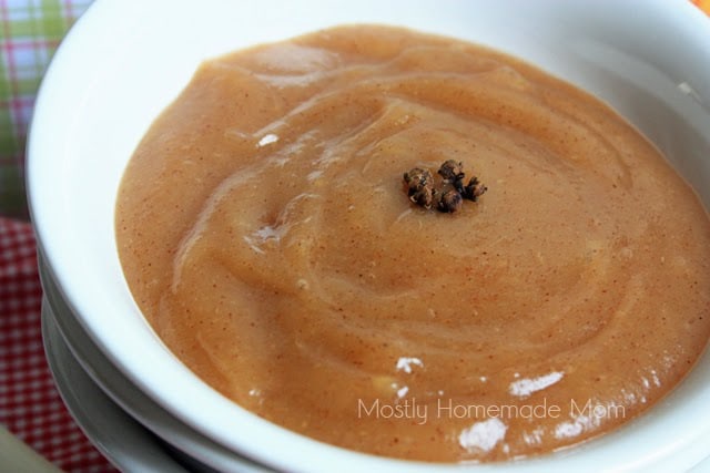 A white bowl filled with sugar free applesauce sweetened with honey and topped with whole cloves