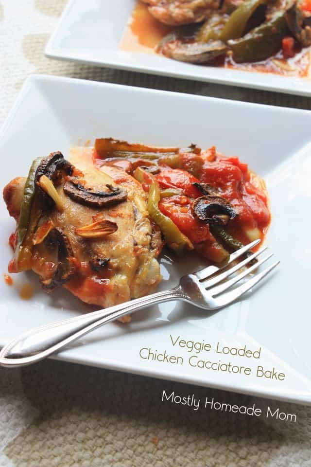 A serving of baked chicken cacciatore on a white square plate with a fork