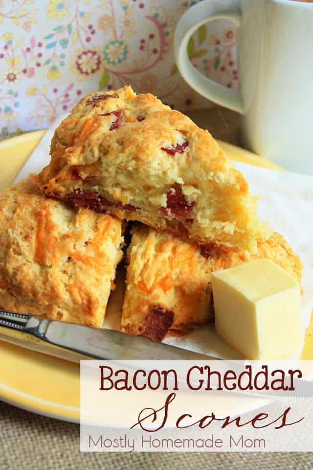 Bacon cheddar scones stacked on a yellow plate next to butter
