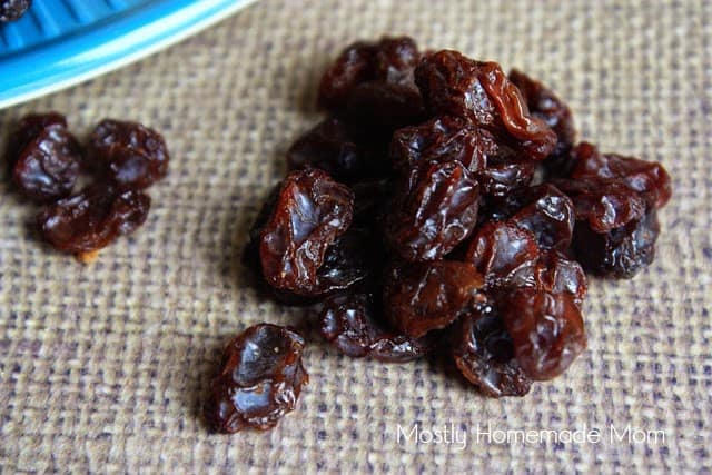 A small pile of raisins on a burlap placemat