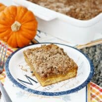 A slice of pumpkin crumb cake on a plate with a napkin.