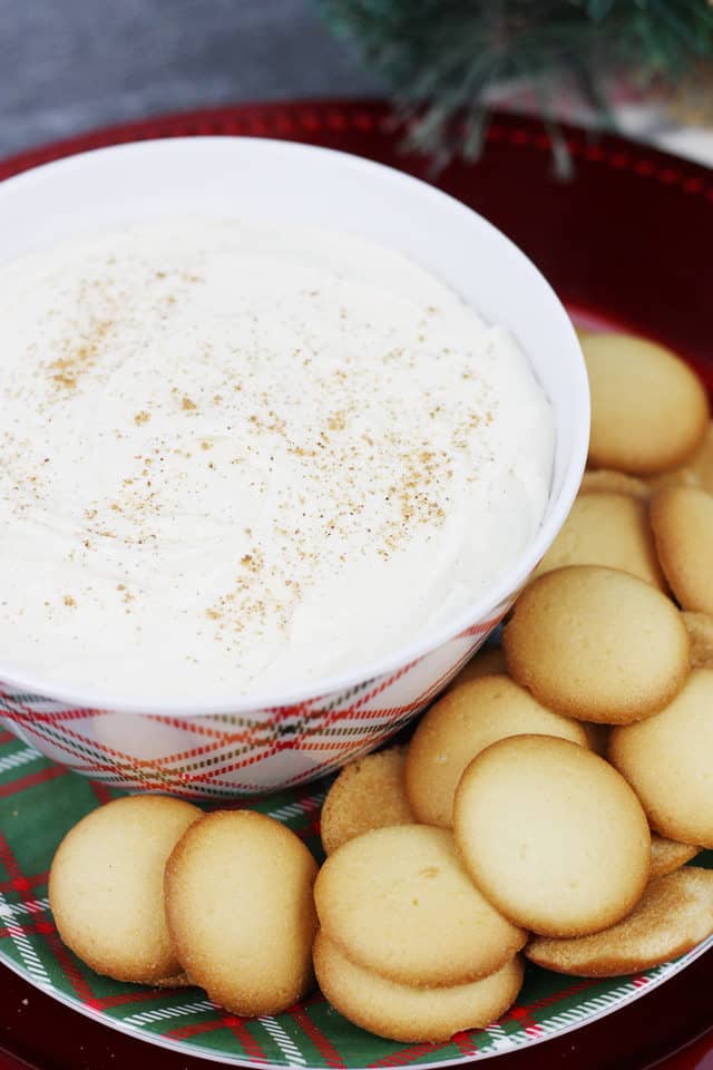 Eggnog cheesecake dip in a serving bowl next to vanilla wafers