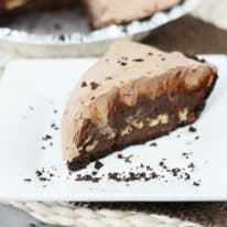 A slice of chocolate mud pie on a white square plate.