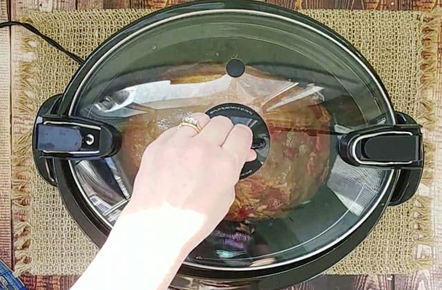 Putting the cover over the brown sugar ham in Crockpot