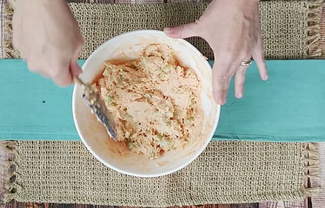 Buffalo chicken salad being mixed in a bowl with a spatula
